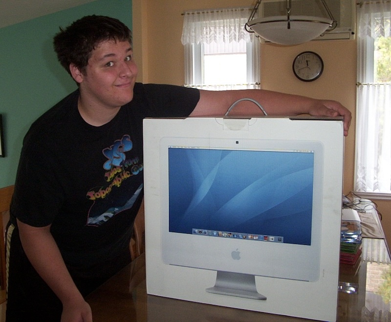 Picture of the author posing with a 20-inch iMac box on a kitchen table